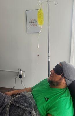 Client receiving IV hydration care in a clinic chair
